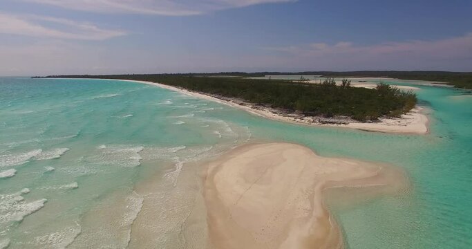 Aerial view of a deserted beach, coral formations and turquoise waters along the shoreline of Orange Creek on Cat Island, Bahamas.