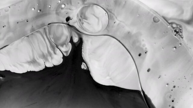 Black and white abstract grunge background. Psychedelic morphing liquid and bubbles, ink transition. Smartphone wallpaper or theme. Minimalistic and stylish background. Chemical reactions with paint.