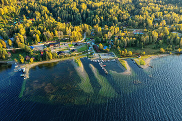 Altai mountains in autumn. Teletskoye lake at dawn. Tourist bases on the shore. Aerial view.