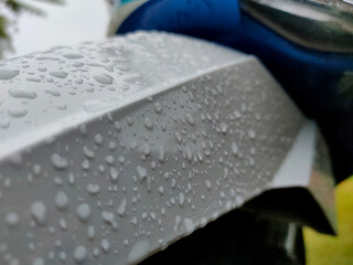 Rain drops on white plastic surface of the motorbike