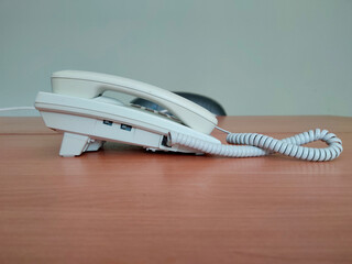 White telephone on a wooden table in the office 