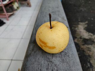 A pear fruit on cement surface.