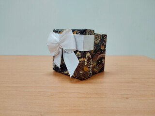 Gift box with white ribbon on the table