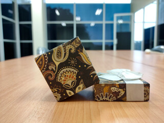 Gift box with white ribbon on the table in the office