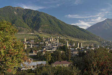 Fototapeta na wymiar Historic tower houses amidst modern buildings on a hillside in Mestia, Svaneti region of the Caucasus, Georgia