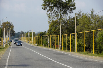 Above-ground natural gas pipes, painted yellow and installed during Soviet times, run alongside a road through Kheta, Georgia. Beware of crossing livestock.