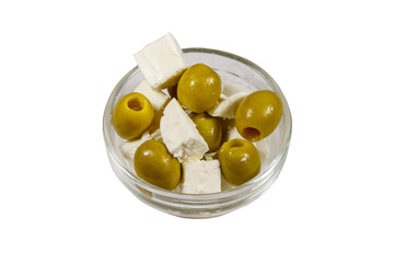 Feta cheese cubes with green olives in glass bowl isolated on white background
