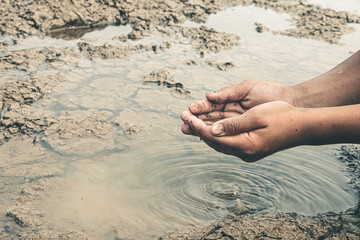 The little boy waiting for drinking water to live through this drought, Concept drought and crisis environment.