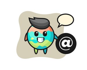 Cartoon Illustration of bath bomb standing beside the At symbol