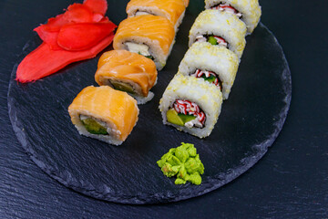 Set of sushi rolls on a black stone slate