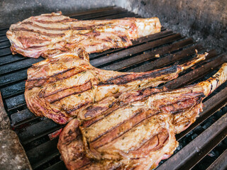 Tomahawk rib beef steak on hot black grill with flames