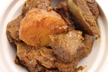 Asian style Beef bhuna dry curry with potato in ceramic bowl over white background