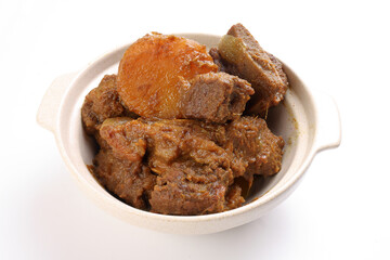 Asian style Beef bhuna dry curry with potato in ceramic bowl over white background