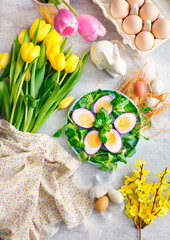 Fototapeta na wymiar Some of the ingredients for the preparation of Spring-Easter eggs stuffed with tuna and avocado. Superb healthy food. The composition is decorated with fresh flowers. American cuisine.