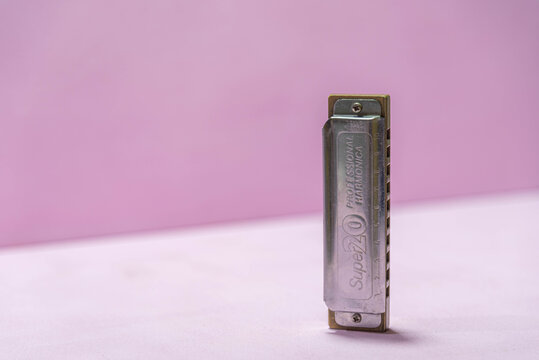 Mouth harmonica on pink background