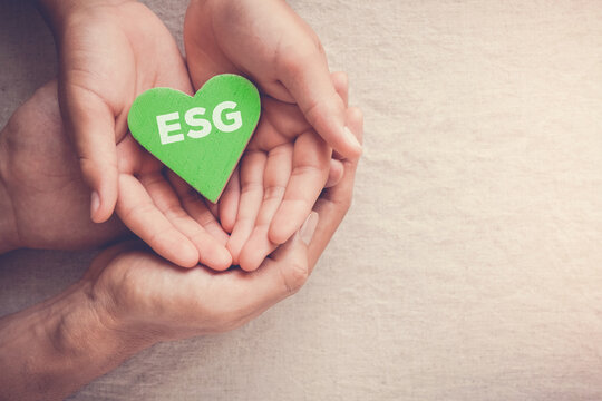 Adult and child hands holding green heart with ESG, Environmental, social and corporate governance concept