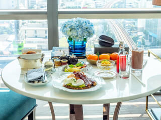 Breakfast set, fried egg, bacon, cereal, milk and pastry on elegant ceramic dish, served in luxury hotel
