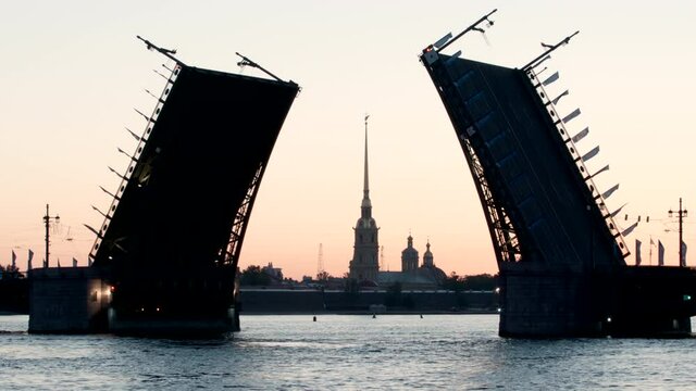 Silhouette of Chapel of Peter and Paul fortress and opened Palace Bridge early morning - St. Petersburg, Russia