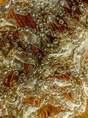 Golden abstract background from the texture of silk ribbons and beads. Christmas decoration for screen design, website, cover, poster