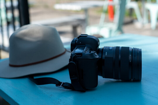 black dlsr camera sitting on a blue table with a hat