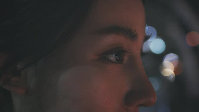 Closeup of teary and upset eyes of young Asian woman feeling depressed and sad while standing in city street looking away