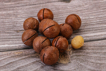 Brown macadamia nut heap over background