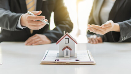 Businessmen and real estate agents introduce clients and negotiate home insurance purchase and sign contracts. Home insurance concept. And selling a home.