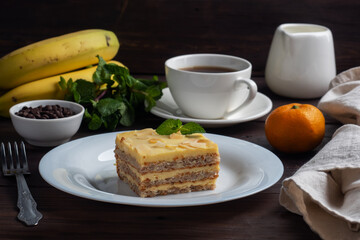 Banana sponge cake with nuts and mint. Delicious sweet dessert for tea, Dark wooden background.