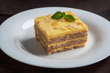 Banana sponge cake with nuts and mint. Delicious sweet dessert for tea, Dark wooden background.