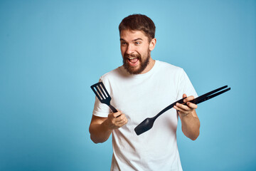 Man in white t-shirt kitchenware cooking food blue background