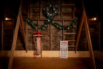 Rustic Christmas Scene in a Wooden Barn with Wreath and Sled