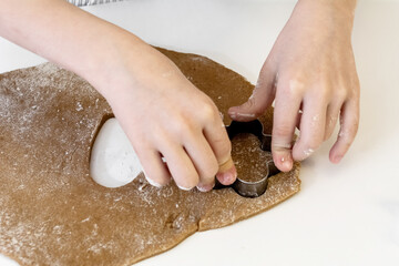 boy of 7-8 years old makes cookies from dough in the form of a flower for the holiday.