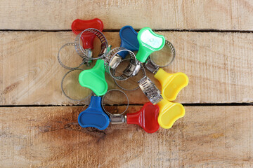 Metal adjustable hose clamps with copy space isolated on wooden background closeup.