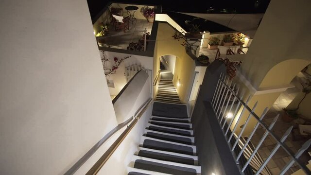 Thira traditional illuminated passage street with stairs at night , Santorini island, Greece