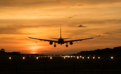 Fototapeta na wymiar Silhouette Airplane will take-off at an airport during sunset sky