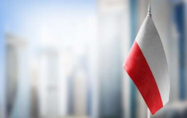 A small flag of Poland on the background of a blurred background