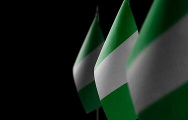Small national flags of the Nigeria on a black background