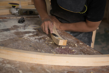 a carpenter using a chisel on a block of wood
