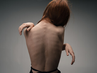 Nude woman touches herself with hands on a light background model cropped view