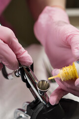 Manicure Master Adds Paint To Airbrush Before Spraying Procedure In Nail Salon. Airbrush work.