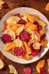 Vegetable chips, overhead shot on a wooden background