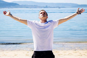 happy and carefree man enjoying the feeling of freedom on the beach