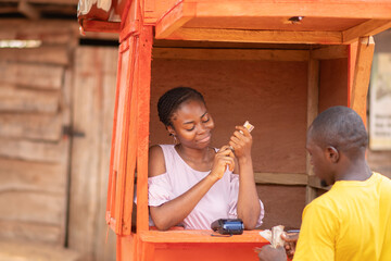 african woman in a kiosk attending to a customer