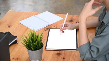 Cropped shot of young woman designer holding stylus pen drawing on digital tablet.