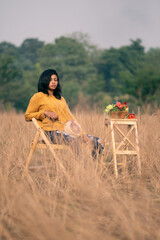 portrait of a young black female model sitting in a field