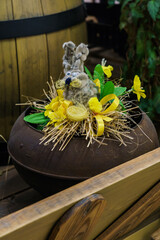 Easter composition of willow in the form of a hare and flowers in a cast iron.