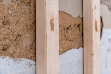 Sanierungsarbeiten, Holzständer vor einer alten Lehmwand.