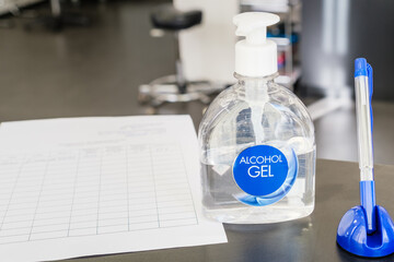 Hand sanitizer at the reception of the salon. Pen and questionnaire for collecting personal information of salon clients.