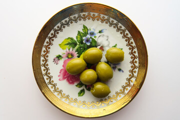 Mediterranean food, olives on a golden plate on a white background