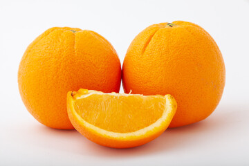 Fresh two whole orange fruit and one segment.